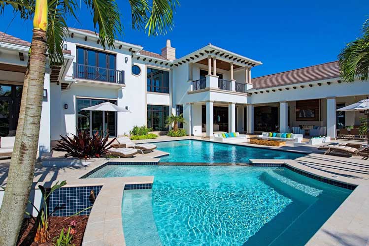 View across the top of the spa and its spill out to the pool at an Estate lot in Estuary - Naples, Florida